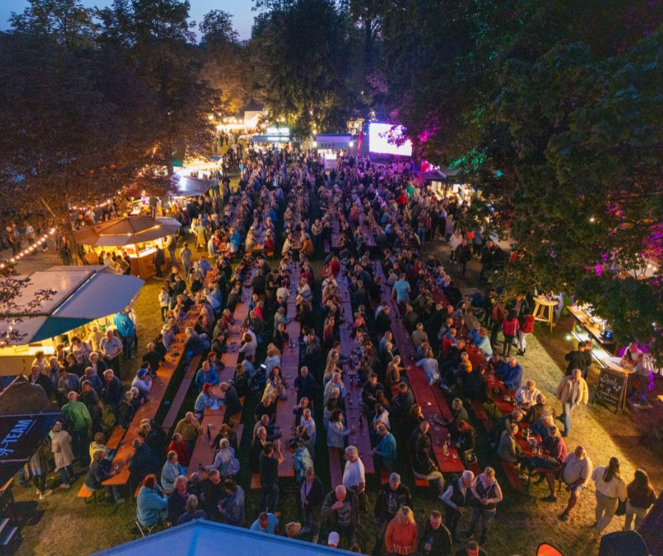 Voll besetzter Festbereich mit Gästen, Lichterketten und Weinabend-Stimmung