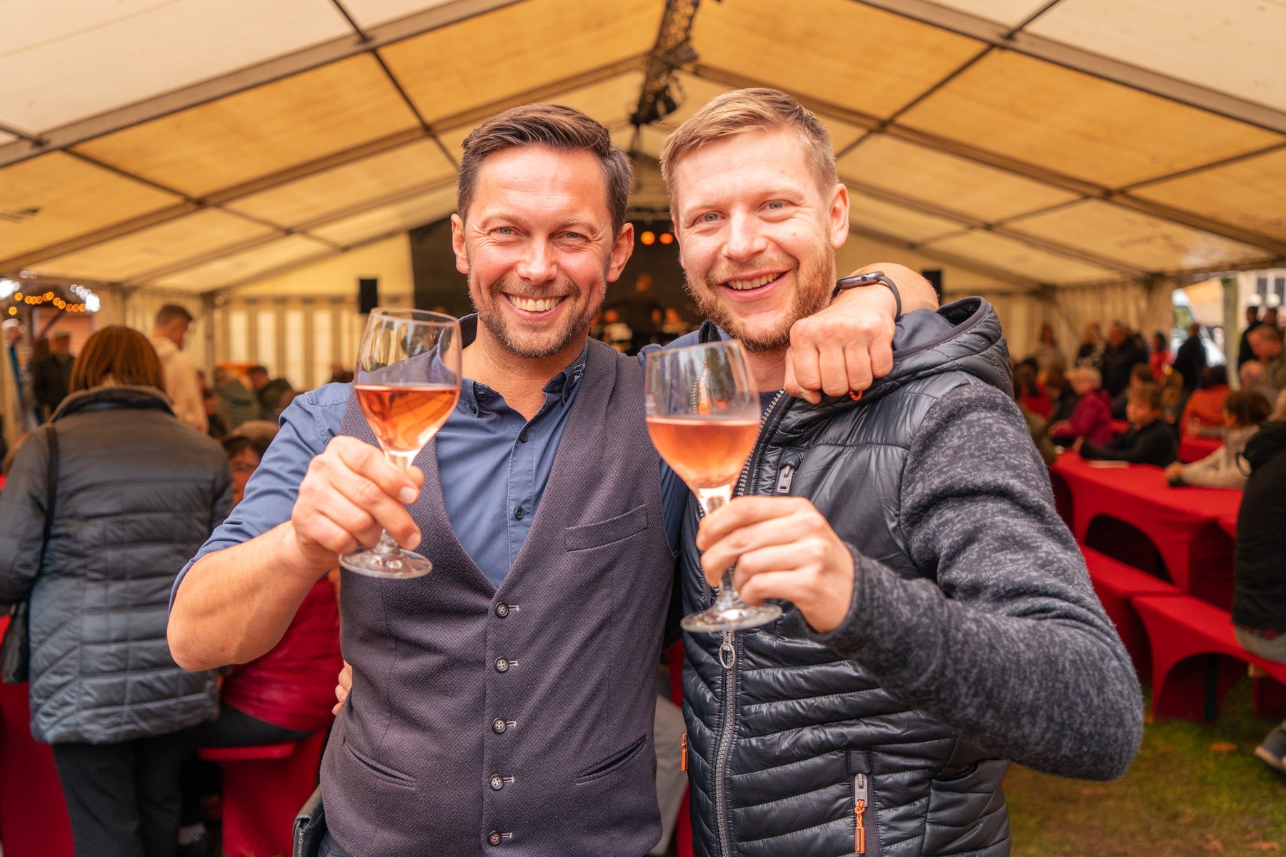 Achim und Angelo, die Veranstalter aus Altenburg, mit Weingläsern im Festzelt